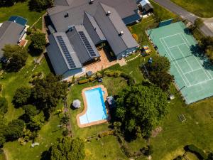 - une vue sur une maison dotée d'un court de tennis dans l'établissement Pine Lodge George, à George
