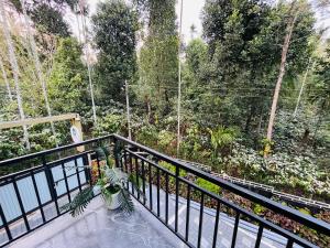 a balcony with a view of a forest at Tea vista holiday home in Kalpetta