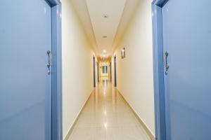 an empty corridor in a hospital with two blue doors at FabHotel Broholic Prime Suites - Nr Nexus Mall, Kukatpally in Kondapur