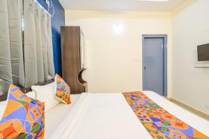 a bedroom with a bed with colorful pillows at FabHotel Broholic Prime Suites - Nr Nexus Mall, Kukatpally in Kondapur