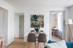 a living room with a table and chairs at Proche centre ville, moderne & cosy, ultra calme in Mulhouse +24 photos