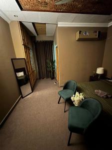 a hotel room with a bed and two chairs at Canadian Guest House in Islamabad