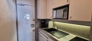 a kitchen with a sink and a microwave at Résidence FlÈche - Studio cabine 4 personnes exposé Sud MAE-3384 in Aime La Plagne +8 photos