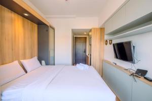 a bedroom with a white bed and a flat screen tv at Best Deal and Comfort Studio Citra Living Apartment By Travelio in Jakarta