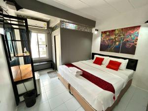 a bedroom with a large bed with red pillows at Khaosan Art Hotel in Bangkok