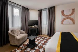 a hotel room with a bed and a chair at BRYQS Hotel KL Sentral in Kuala Lumpur