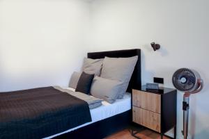 a bedroom with a bed with a fan and a dresser at KOCAK - Exklusives Apartment im Zentrum in Reutlingen