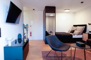 a bedroom with a bed and a chair and a table at KOCAK - Exklusives Apartment im Zentrum in Reutlingen