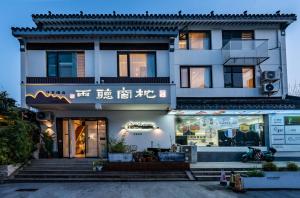 un edificio bianco con scritte su un lato di Pillow Window & Listen to Rain Hostel Museum Branch Pingjiang Road, Suzhou a Suzhou
