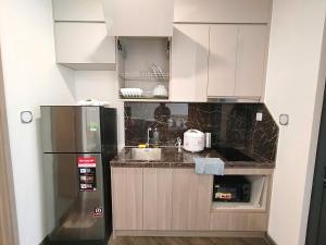 a kitchen with white cabinets and a refrigerator at BIG PROMO Vinhomes Skypark Bac Giang - Modern Apartment in Bắc Giang +5 photos
