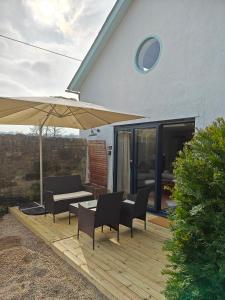a patio with a table and chairs and an umbrella at Lovely 2 bed annexe near Salisbury in Salisbury