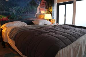 a bedroom with a large bed with a painting on the wall at Luxury Manzil in Lahore