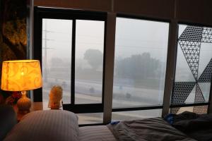 a room with a large window with a bed and a lamp at Luxury Manzil in Lahore