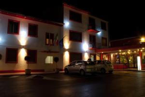 dos autos estacionados frente a un edificio por la noche en Hotel Due Ragni, en Villorba