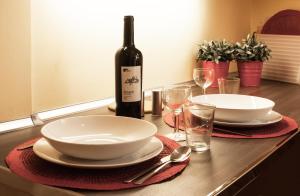 a table with a bottle of wine and plates and glasses at BmyGuest - Santa Catarina Light Apartment in Porto