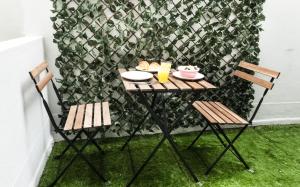 a table with two chairs and a table with food on it at BmyGuest - Santa Catarina Light Apartment in Porto