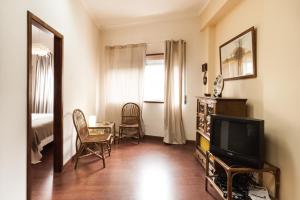 a living room with a tv and a table and chairs at BmyGuest - Santa Catarina Light Apartment in Porto