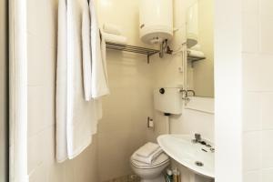 a white bathroom with a toilet and a sink at BmyGuest - Santa Catarina Light Apartment in Porto