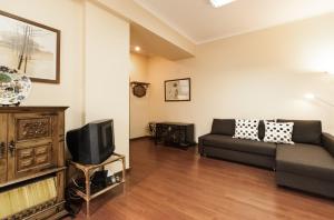 a living room with a couch and a tv at BmyGuest - Santa Catarina Light Apartment in Porto