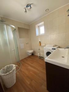 a bathroom with a sink and a washing machine at Domki na Mazurach Pluszkiejmy in Pluszkiejmy