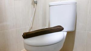 a toilet in a bathroom with a brown towel on it at Spacious 2BR at Pakubuwono Terrace Apartment By Travelio in Jakarta +18 photos