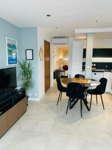 a dining room and living room with a table and chairs at Appartement Saint-Raphaël in Saint-Raphaël