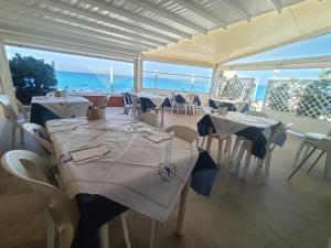 a restaurant with tables and chairs with a view of the ocean at Residence Il Turistico in Zambrone