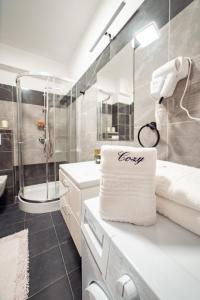 een badkamer met een douche en een witte handdoek bij COZY Premium Collection - Q Studios Palas Mall Iasi in Iaşi