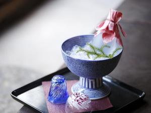 a blue bowl of food on a table with a candle at Kinjohro in Kanazawa