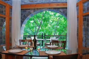 a dining room with a table and a large window at Giannikaki's Villas in Prína