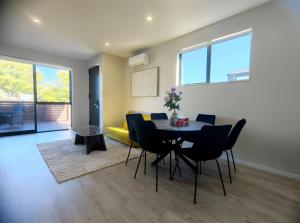a dining room with a table and chairs at Stylish 4BR Home, Netflix, Walk to Eateries and Schools in Auckland