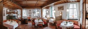a restaurant with tables and chairs in a room at Romantik Hotel zur Post in Fürstenfeldbruck