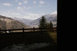 a fence with a view of snow covered mountains at Snowflake Appartamenti Jouvenceaux in Sauze dʼOulx
