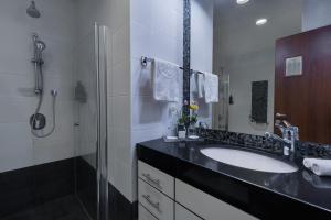 a bathroom with a sink and a shower at Kfar Maccabiah Business & Sport Hotel in Ramat Gan