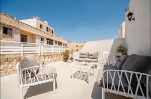 a group of chairs and tables on a patio at Cozy Duplex Apartment by SF Homes in Rabat