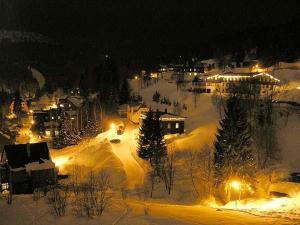 a town covered in snow at night with lights at Pension-Apartmany Apollo in Špindlerův Mlýn