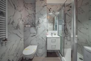 a bathroom with a shower and a toilet and a sink at CozyCollection Apartments at Q Residence #6 in Iaşi +76 photos