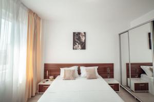a bedroom with a large white bed and a mirror at CozyCollection Apartments at Q Residence #6 in Iaşi