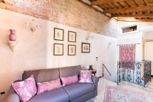 a living room with a couch and pink pillows at Cà Manzoni Apartment with Terrace in Venice