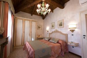 a bedroom with a bed and a chandelier at Cà Manzoni Apartment with Terrace in Venice