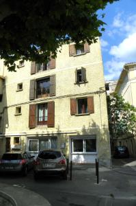 a building with cars parked in front of it at Provencal Vintage Cocoon in LʼIsle-sur-la-Sorgue