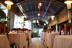 a dining room with tables and chairs and chandeliers at Sailing Hotel Phú Quốc in Phú Quốc