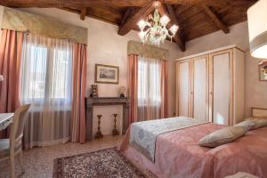 ヴェネツィアにあるCà Manzoni Apartment with Terraceのベッドルーム1室(ベッド1台、テーブル、シャンデリア付)