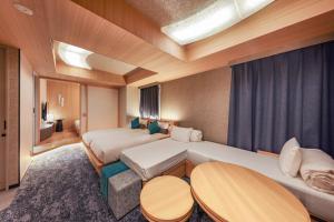 Hotel Keihan Tenmabashi Ekimae في أوساكا: غرفة فندقية بسريرين ونافذة