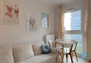 グダニスクにあるCoast Apartment with Sauna & Gym, 5 Min to Baltic Sea & Polsat Plus Arenaのソファとテーブルのあるリビングルーム