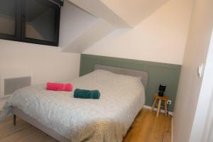 a bedroom with a bed with two pillows on it at Le Cocon Minier, Gare - centre in Lens