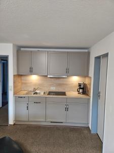 a kitchen with white cabinets and a sink at Ferienwohnungen Wiese in Norddeich +31 photos