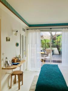 a room with a desk and a table with a blue rug at Hotel des Dunes in Cap-Ferret