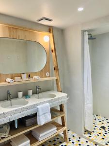 a bathroom with a sink and a mirror at Hotel des Dunes in Cap-Ferret