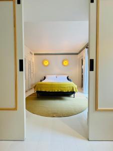 a bedroom with a bed with a yellow bedspread at Hotel des Dunes in Cap-Ferret
